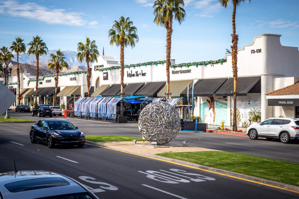 Public sculpture, palms, and storefronts along El Paseo in Palm Desert, photographed in 2021.