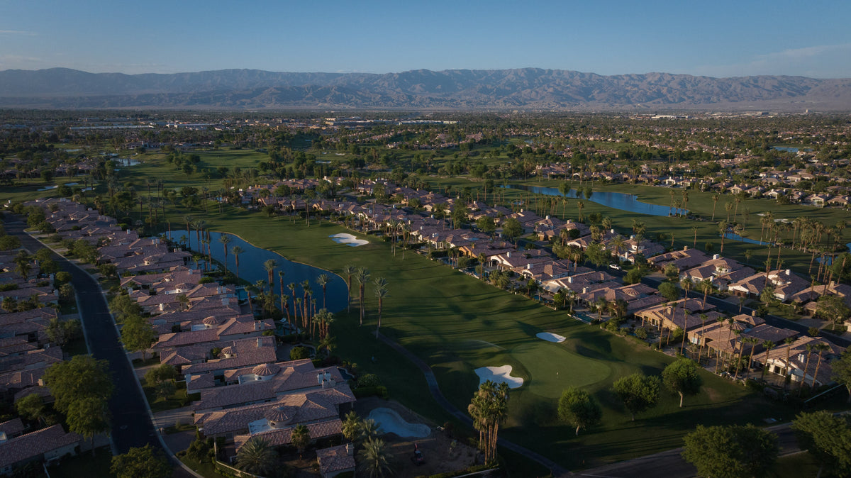 Elevated panorama of Rancho La Quinta Country Club homes, fairways, lakes and mountain backdrop. Photograph by Mark Miller, June 12, 2026.