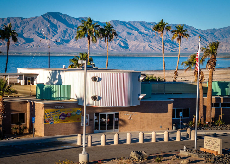 North Shore Beach and Yacht Club community center with palm trees, Salton Sea and mountains