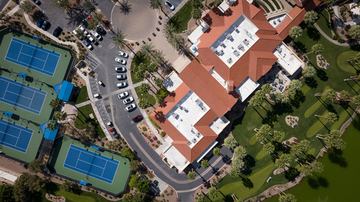 Mark Miller’s aerial photograph of the Montecito Clubhouse at Sun City Shadow Hills, with tennis courts, parking and landscaped grounds.