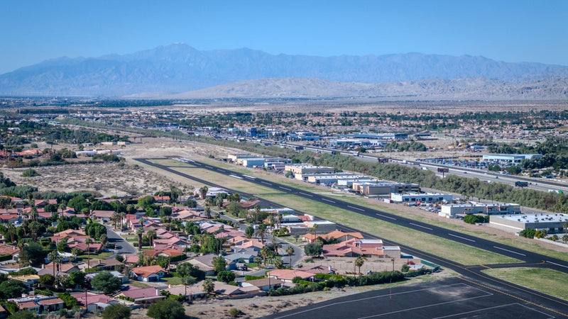 Bermuda Dunes Airport runway within the surrounding desert neighborhoods, with distant mountains. Photograph by Mark Miller, October 26, 2026.