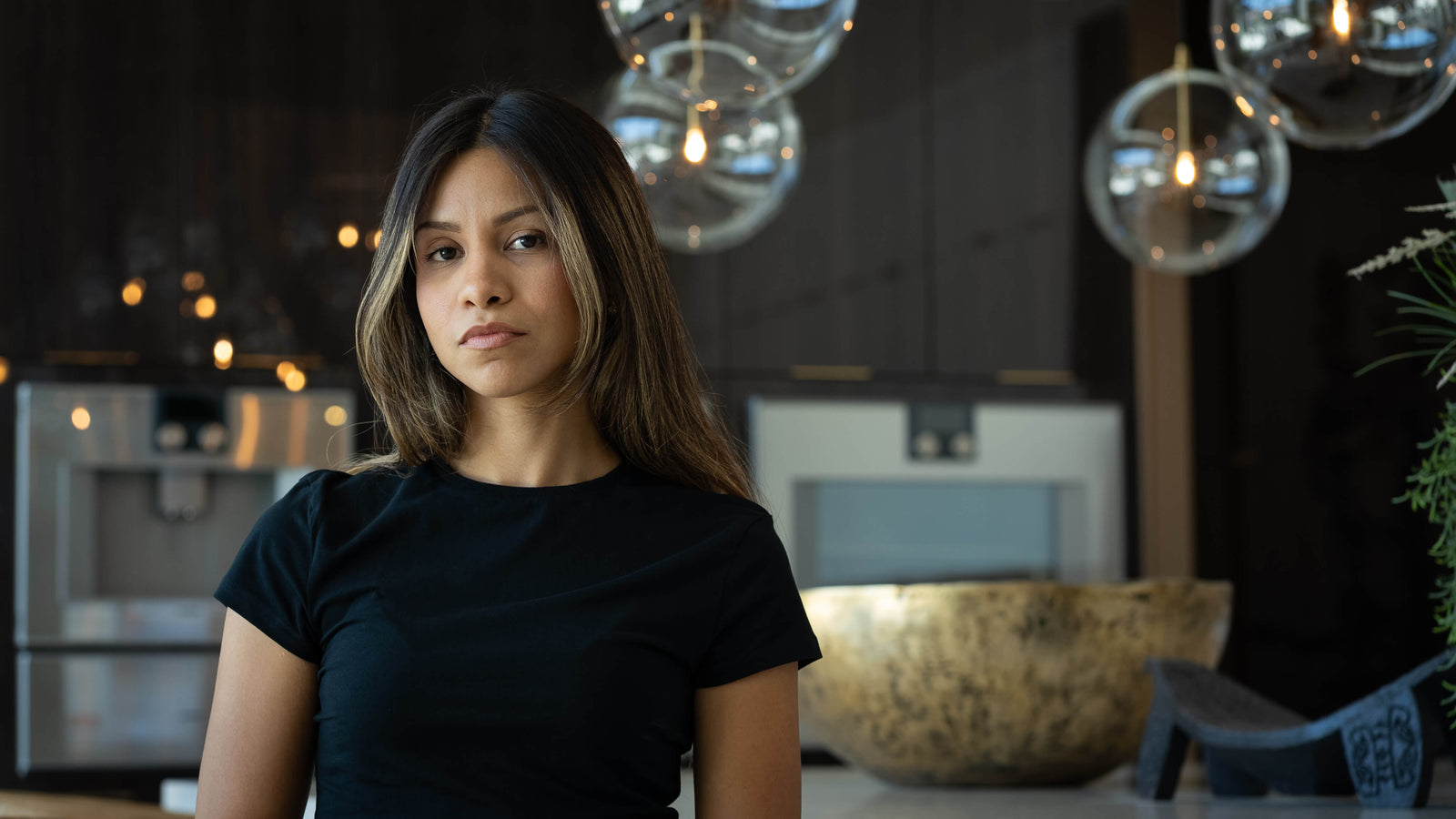 Portrait of Christina Mainez in a modern model home with pendant lighting