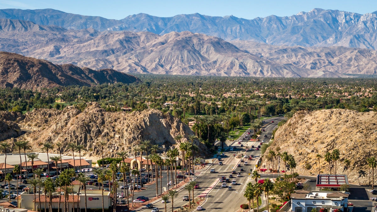 Highway 111 winds between rocky hills, palm-lined neighborhoods and mountains in the Coachella Valley. Photo by Mark Miller.