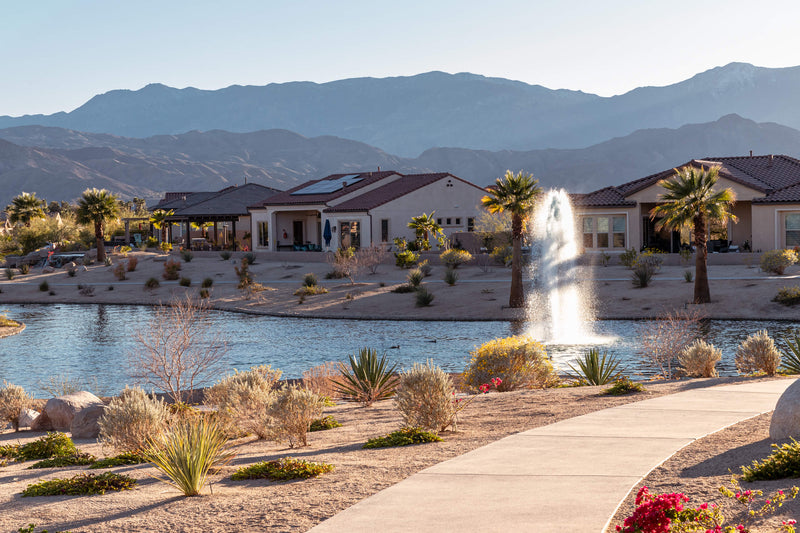 Walking path beside a fountain lake and homes at Del Webb Rancho Mirage