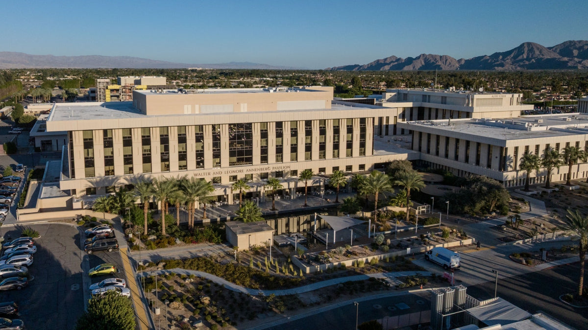 Walter and Leonore Annenberg Pavilion at Eisenhower Medical Center, with palms and mountains.