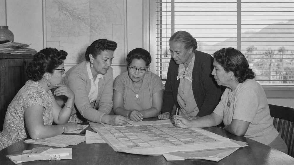 AI-generated historical reenactment of five Agua Caliente women leaders reviewing Palm Springs land plans; not an archival photograph.