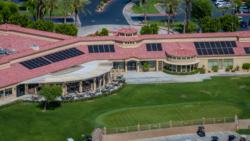 Aerial view of Heritage Palms clubhouse, outdoor dining patio, and golf practice green in Indio