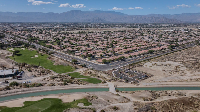 View from the Indio Hills across the canal, trail parking, golf course and neighborhoods toward the mountains. Photograph by Mark Miller, September 29, 2026.