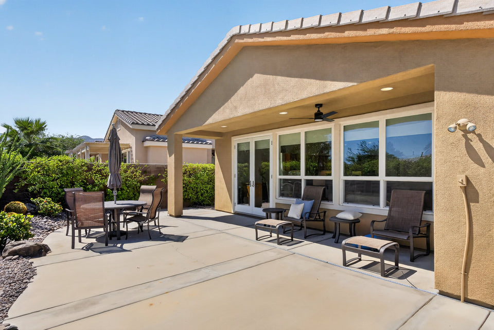 Covered rear patio with lounge seating at the Juniper Lane seasonal rental in La Quinta