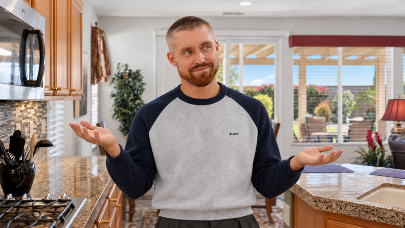 AI-generated portrait of Mark Miller weighing two home options with both palms raised in a Coachella Valley kitchen.