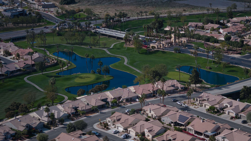 Aerial view of Sun City Palm Desert entrance, golf course and homes