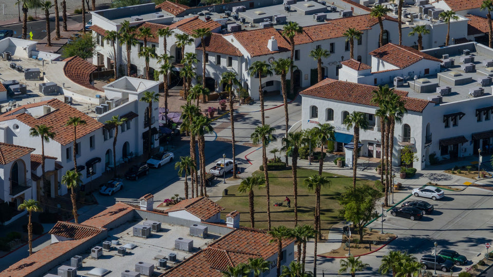 Palm-lined streets, white stucco storefronts, red tile roofs, and the central plaza in Old Town La Quinta, September 23, 2026. Photograph by Mark Miller.