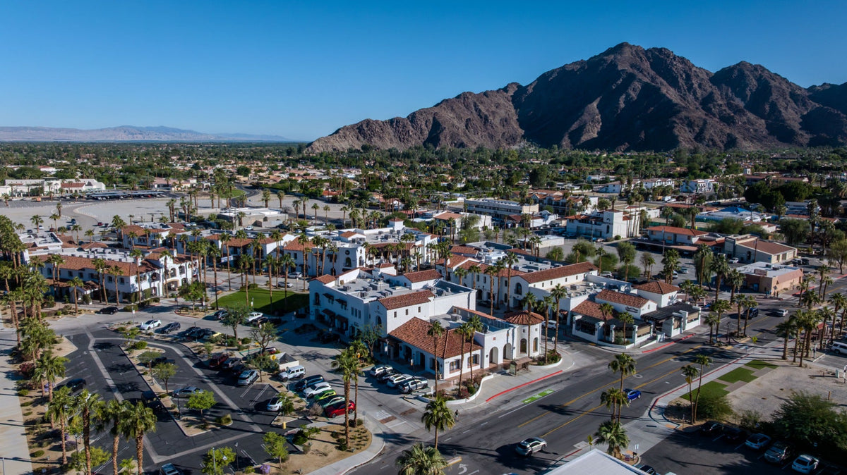 Aerial view of Old Town La Quinta and the surrounding village, with palm-lined streets and the Santa Rosa Mountains behind.