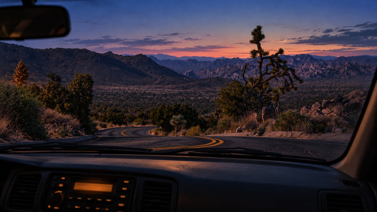 AI-generated dusk view through a car windshield toward a winding Joshua Tree road, based on a photograph by Mark Miller
