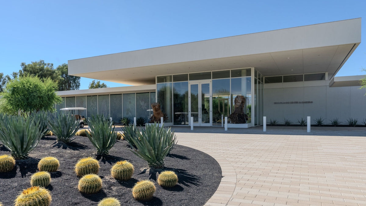 Agaves and golden barrel cacti beside the glass entrance of Sunnylands Center in Rancho Mirage.