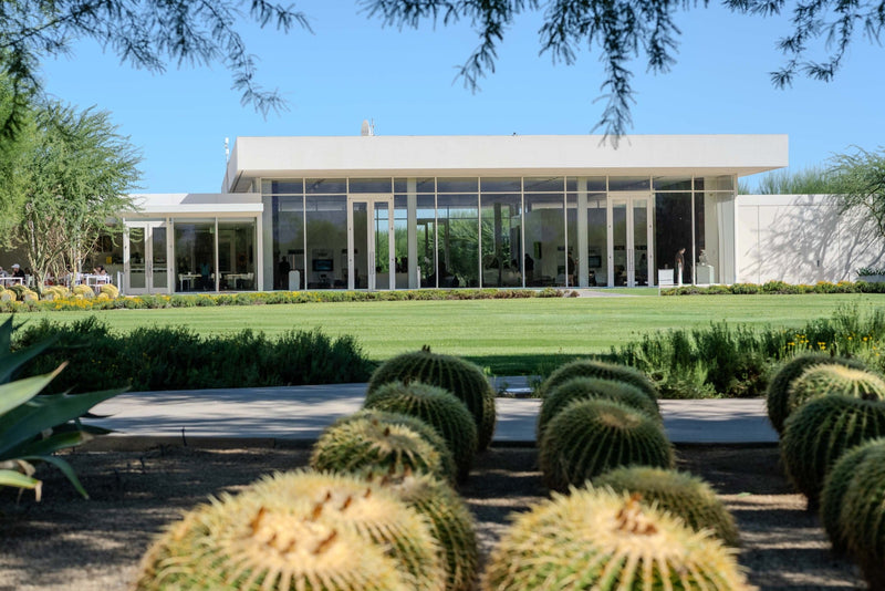 Golden barrel cacti in the foreground, green lawn in the middle, and Sunnylands Center in the center of the frame in Rancho Mirage, photographed by Mark Miller.