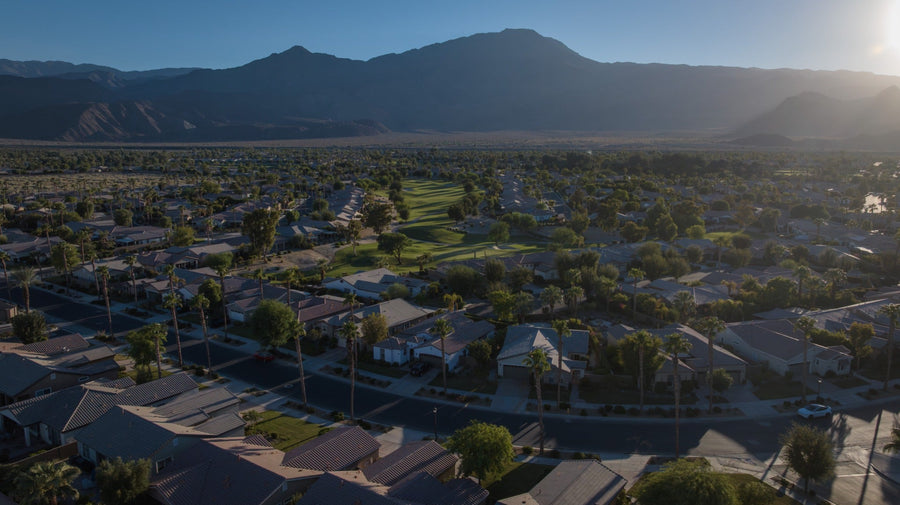 Aerial view of Trilogy La Quinta homes and golf course with mountains in the background