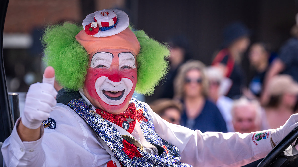 Harpo the Clown giving a thumbs-up in front of a crowd