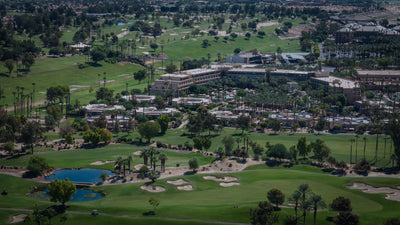Wide aerial view of Grand Hyatt Indian Wells amid golf courses and water features.