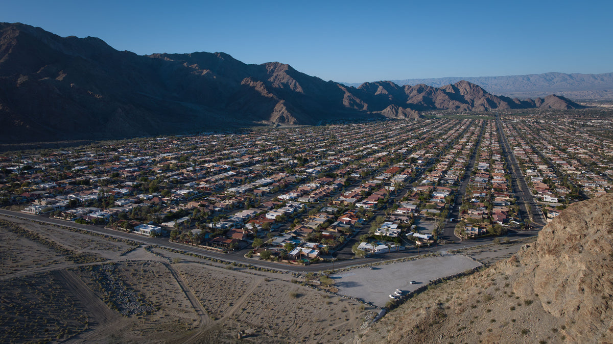 Wide aerial view of La Quinta Cove’s street grid and homes beneath the Santa Rosa Mountains, February 2026.