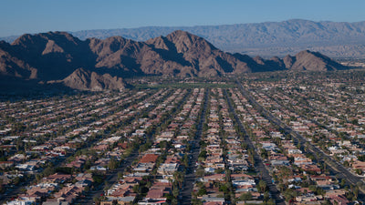 Elevated view along parallel residential streets in La Quinta Cove toward rugged mountains, February 2026.