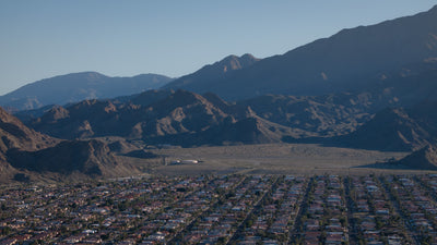 Homes at the upper edge of La Quinta Cove beside open desert and layered mountain ridges.