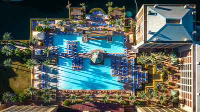 Overhead view of Renaissance Esmeralda's pool deck, palm trees, loungers and hotel wing.
