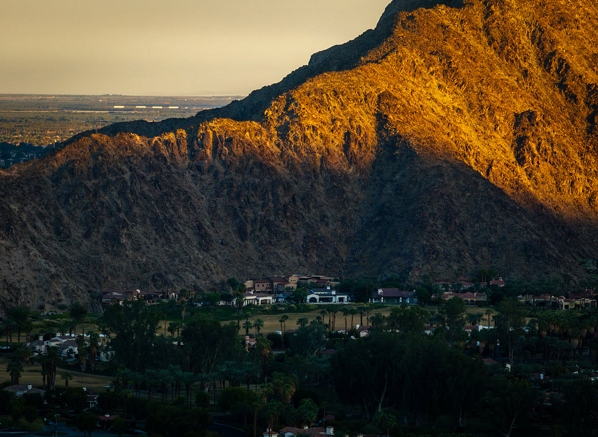 A scenic view of the Santa Rosa Mountains in La Quinta, showcasing the mountain range with a warm glow on its slopes at sunset.