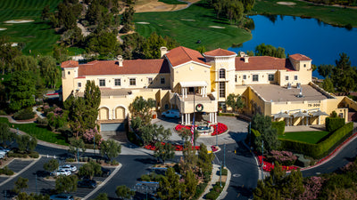 Aerial view of The Classic Club clubhouse with the course and lake behind it.