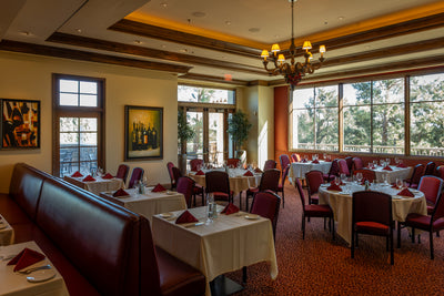 Bellatrix dining room at The Classic Club with white tablecloths and red chairs.