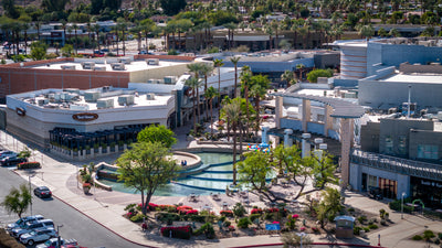 Wide aerial view of The River’s central promenade, restaurants, shops and landscaped waterways in Rancho Mirage