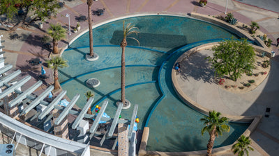 Aerial view of The River’s curved lagoon, palm trees, seating and pedestrian walkways in Rancho Mirage