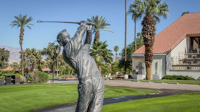 Close view of the Arnold Palmer statue with palms and the clubhouse behind it at Bermuda Dunes Country Club, California. Photograph by Mark Miller.