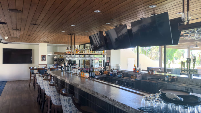 Clubhouse bar beside windows overlooking the golf course at Bermuda Dunes Country Club, California. Photograph by Mark Miller.
