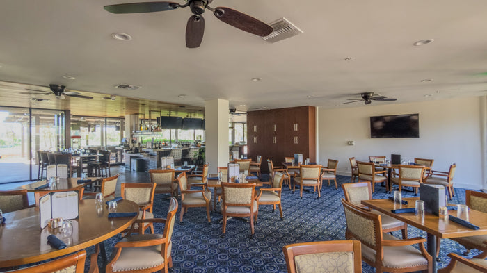 Clubhouse lounge with armchairs and windows overlooking the grounds at Bermuda Dunes Country Club, California. Photograph by Mark Miller.