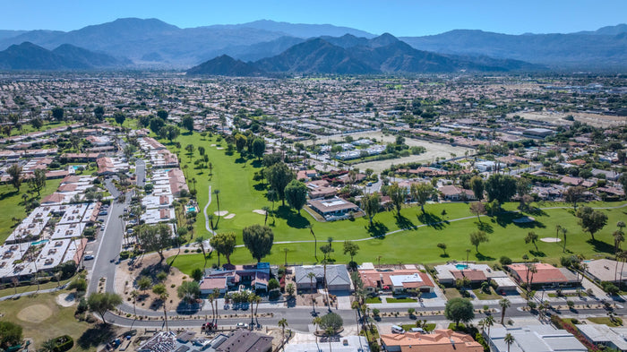 Wide aerial view of the community and a long fairway extending toward the mountains at Bermuda Dunes Country Club, California. Photograph by Mark Miller.