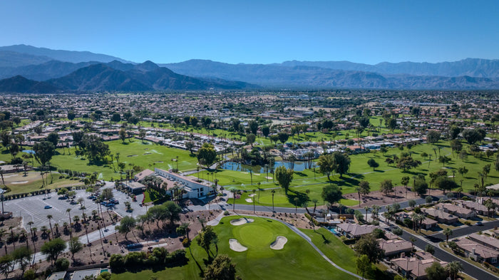 Wide aerial view of the golf community, lakes, fairways and distant mountains at Bermuda Dunes Country Club, California. Photograph by Mark Miller.