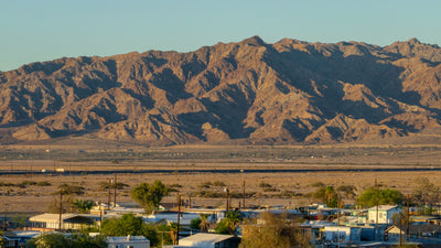 Sunlit rugged mountains rising beyond Bombay Beach, photographed by Mark Miller in September 2026
