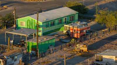 Bright green and orange buildings along a Bombay Beach street, photographed by Mark Miller in September 2026