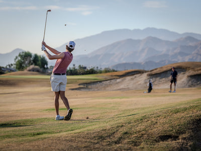 Golfer watching a shot with layered mountain ridges behind the course. Photo by Mark Miller, Cathedral City, September 26, 2026.