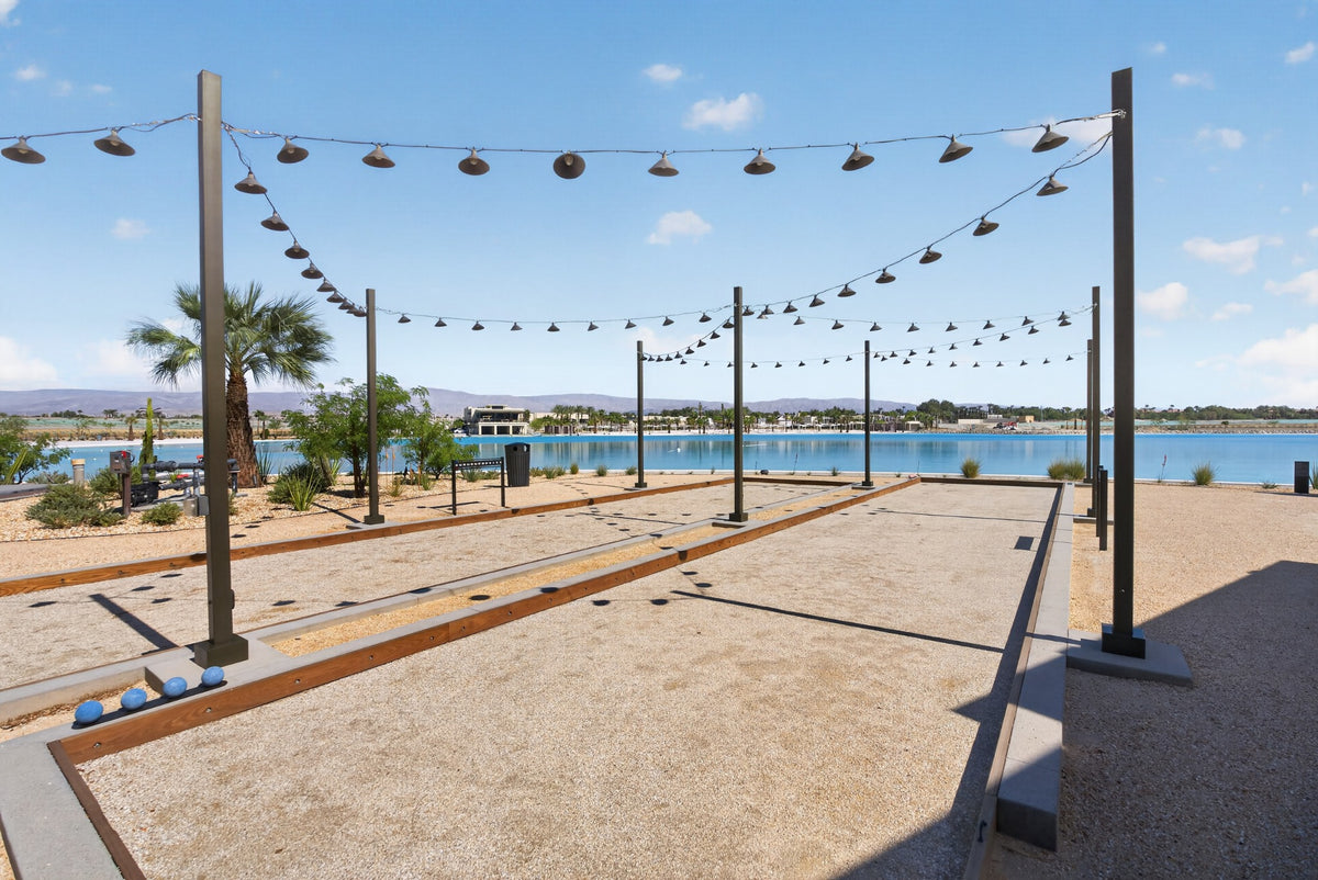 Bocce courts overlooking Cotino Bay, with string lights, palms and waterfront seating. Photograph by Mark Miller, October 13, 2026.