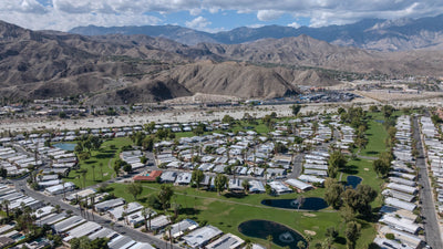 Wide aerial of Date Palm Country Club fairways, ponds and surrounding mountains.
