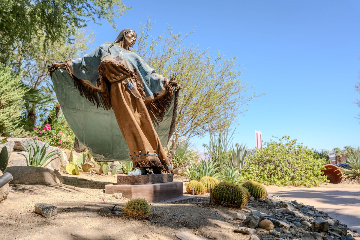Full view of Dave McGary’s Walks Among the Stars, a painted bronze figure in the desert landscape at Faye Sarkowsky Sculpture Garden.