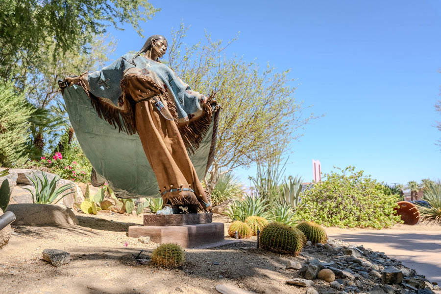 Full view of Dave McGary’s Walks Among the Stars, a painted bronze figure in the desert landscape at Faye Sarkowsky Sculpture Garden.