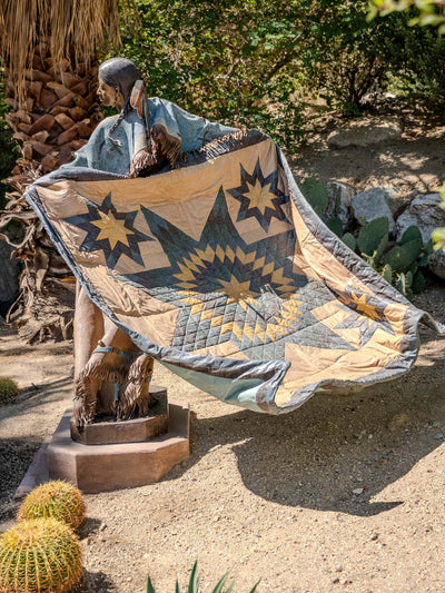 Star-patterned quilt held by the figure in Dave McGary’s Walks Among the Stars at Faye Sarkowsky Sculpture Garden.