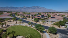 Single-story homes, landscaped green space and mountain backdrop at Del Webb Rancho Mirage, California