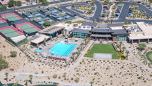 The Outlook pool, lawn and clubhouse with the court complex behind at Del Webb Rancho Mirage, California