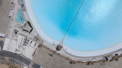 Overhead view of the lagoon beach, pool and shaded lounge areas at DSRT Surf in Palm Desert, September 10, 2026.