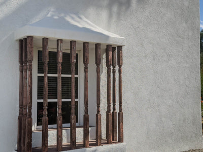 Wooden window grille and white stucco wall at the El Mirador complex. Photograph by Mark Miller, October 20, 2026.