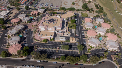 Wide overhead view of Embassy Suites La Quinta showing the main hotel, parking areas, and neighboring buildings.